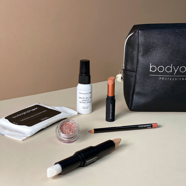 Bodyography Beauty Editor Go-To Collection: From left to right - 10 count Cleansing and Soothing Wipes, Glitter Pigment in Celestial, Inner Glow Stick, Mini Ready Set Go Makeup Setting Spray, Lip Pencil in Pouty, Fabric Texture Lipstick in Chiffon, Black vinyl bag